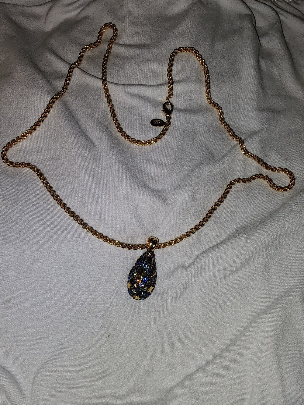 Vintage Fabergé-style egg pendant necklace featuring dark blue crystals